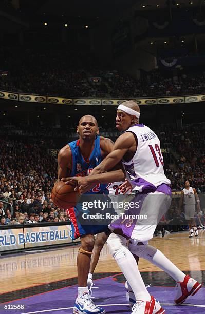 Guard Jerry Stackhouse of the Detroit Pistons wrestles with forward Jerome Williams of the Toronto Raptors during game 3 of the Western Conference...