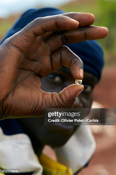 Miner shows off the estimated 5 to 7 carat diamond just found in his concession 28 March 2013 near an Angolan village not far from the Congolese...