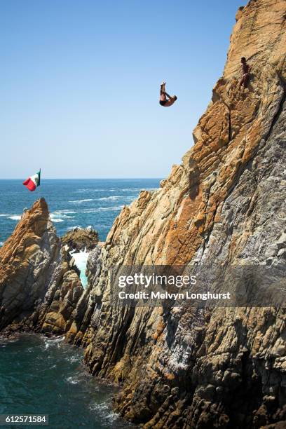 cliff diver, a clavadista, diving off the cliffs at la quebrada, acapulco, guerrero state, mexico - acapulco autumn stock pictures, royalty-free photos & images