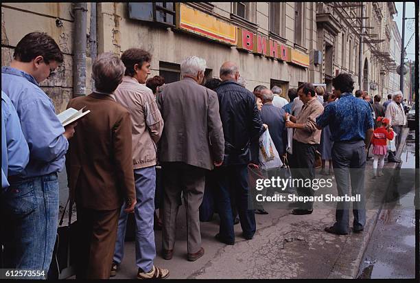 Normalcy returns to Moscow after the coup as dozens of people wait in food lines along a wet street.
