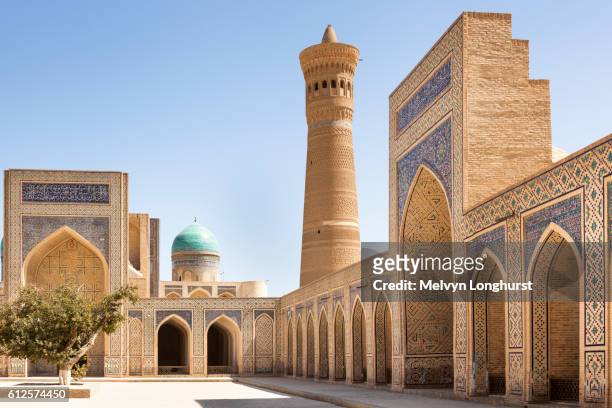 kalon mosque courtyard, also known as kalyan mosque, kalon minaret and mir i arab madrasah behind - minaret - fotografias e filmes do acervo