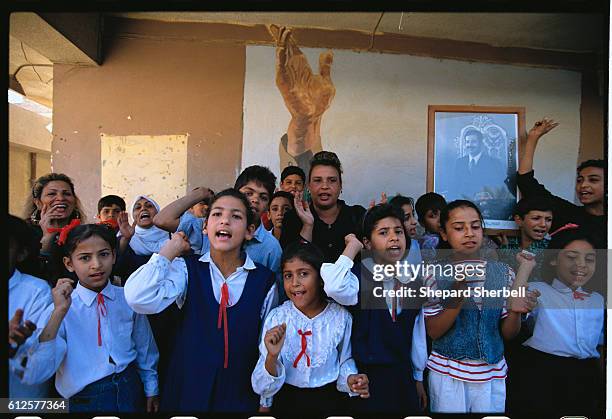 Iraqi schoolchildren rally for Saddam Hussein during the voting in the presidential referendum.