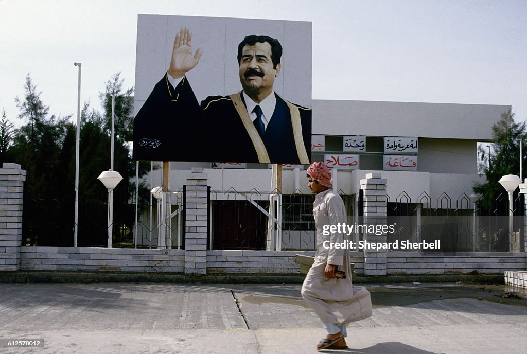 Pedestrian Passing Large Saddam Hussein Billboard