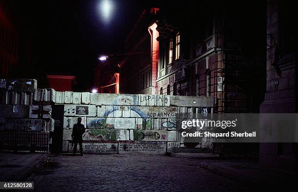Soldier stands guard at the parliament building, in Riga, Latvia, in front of a wall covered with graffiti in support of Latvia. The wall was erected...