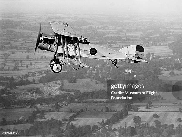 Used during World War I as a fighter and reconnaisance plane, a Bristol F.2.B BRISFIT biplane flies over the countryside in the 1920's.