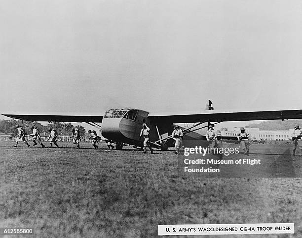 During war game exercises in the early 1940's, U. S. Troops disperse from a Waco CG-4A cargo glider.