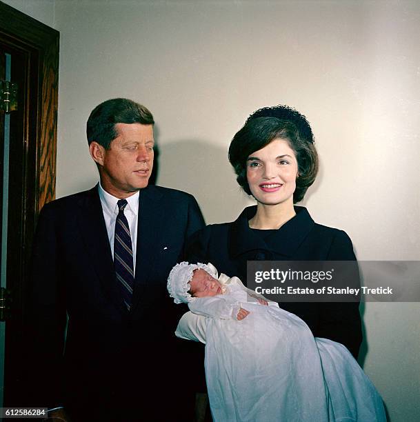 President John F. Kennedy with wife Jaqueline, holding her son John Jr. Just after his christening at the Georgeown University Hospital Chapel. His...