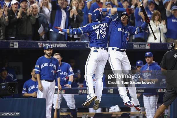 Jose Bautista of the Toronto Blue Jays celebrates with Troy Tulowitzki after hitting a solo home run in the second inning against the Baltimore...