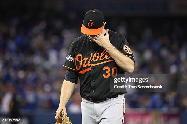 Chris Tillman of the Baltimore Orioles walks back to the dugout after the second inning against the Toronto Blue Jays during the American League Wild...