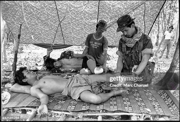 Guerillas of the Khmer People's National Liberation Front retreating towards the Thai border with their wounded, after having attacked a Vietnamese...