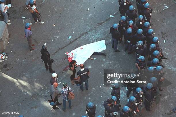 Young protester was shot dead by a member of the carabinieri, during the anti-globalization riots.A group of police encircle the body as it is taken...