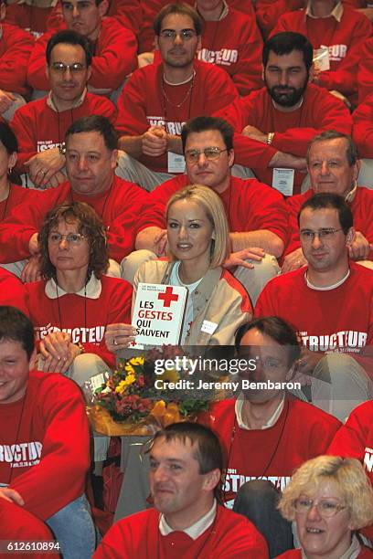Model Adriana Karembeu presenting the Red Cross guide 'Les gestes qui sauvent' with members of the humanitarian organization.