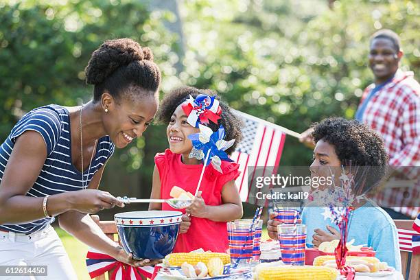 mutter und kinder feiern 4. juli - asian eating hotdog stock-fotos und bilder