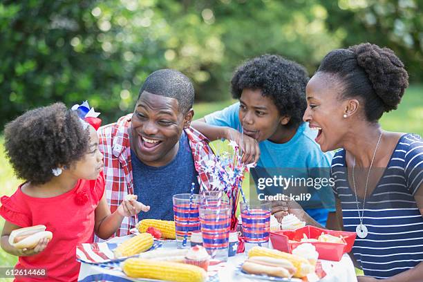 african american mixed race family at july 4th picnic - asian eating hotdog stockfoto's en -beelden