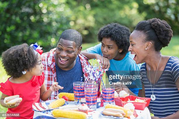 african american mixed race family at july 4th picnic - asian eating hotdog stock pictures, royalty-free photos & images
