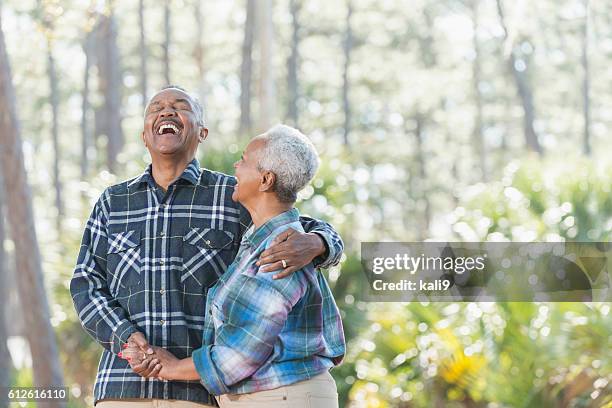 senior afroamerikanische paar hält hände im park - african american hiking stock-fotos und bilder