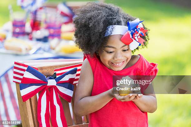 mixed race little girl having cupcake on 4th of july - free six photo stock pictures, royalty-free photos & images