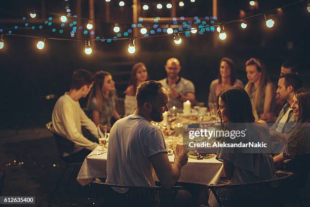 friends gathered over dinner - restaurant outside night stock pictures, royalty-free photos & images