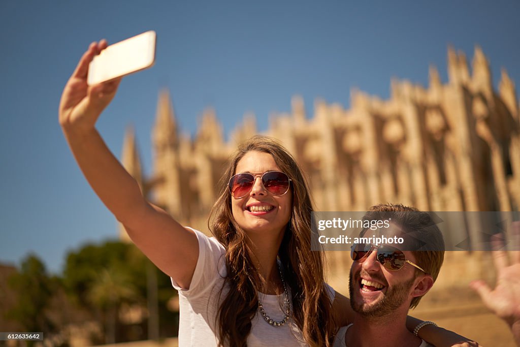 Couple taking selfie in front of cathedral