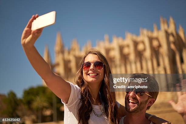 couple taking selfie in front of cathedral - palma maiorca stockfoto's en -beelden