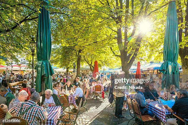 sunny beer garden in munich, bavaria, germany - munich stock pictures, royalty-free photos & images