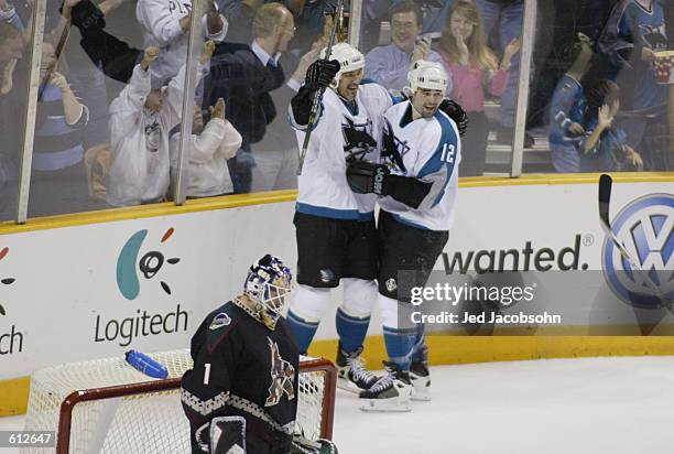 Patrick Marleau and Stephane Matteau of the San Jose Sharks celebrate Marleau's goal as goalie Sean Burke of the Phoenix Coyotes is dejected during...