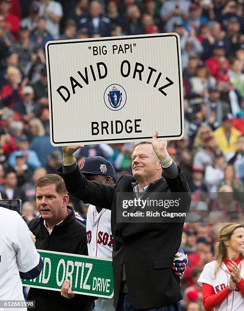 Massachusetts governor Charlie Baker holds up the sign that will soon be on the Brookline Avenue bridge near Fenway Park, named the 'Big Papi' David...