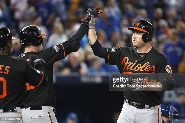 Mark Trumbo of the Baltimore Orioles high fives Matt Wieters after hitting a two-run home run in the fourth inning against the Toronto Blue Jays...