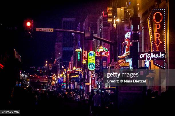 neon signs on lower broadway (nashville) at night - nashville photos et images de collection