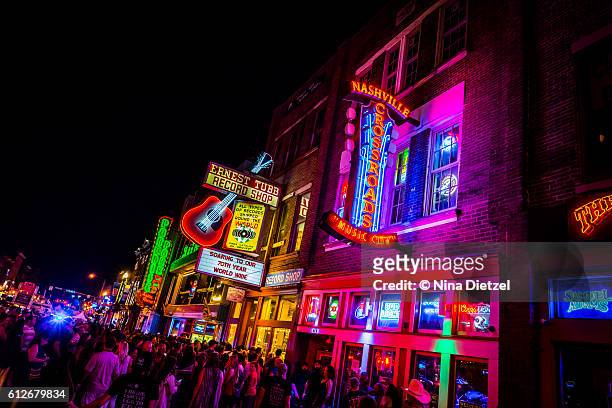 neon signs on lower broadway (nashville) at night - nashville imagens e fotografias de stock