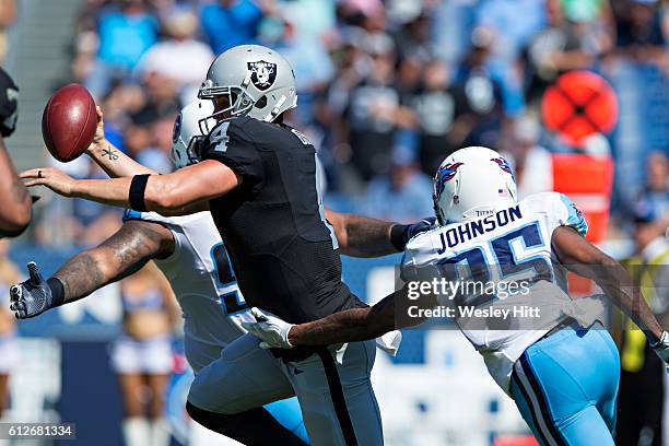 Derek Carr of the Oakland Raiders tries to avoid the rush of Rashad Johnson of the Tennessee Titans at Nissan Stadium on September 25, 2016 in...