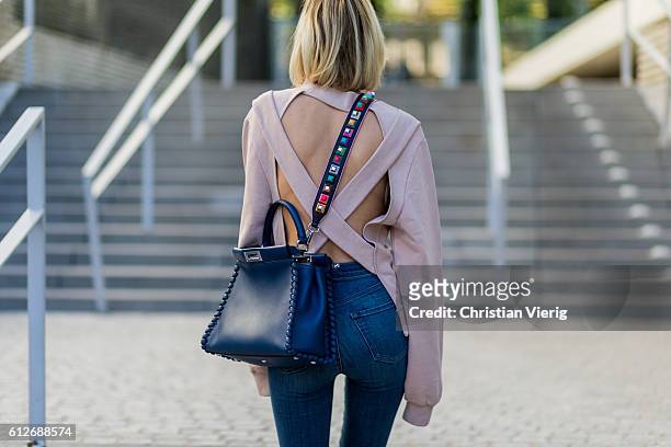 German fashion blogger Lisa Hahnbueck wearing pink Off-White Backless Sweatshirt, JBrand Highwaist Jeans, blue FENDI Pekaboo Bag, on October 4, 2016...