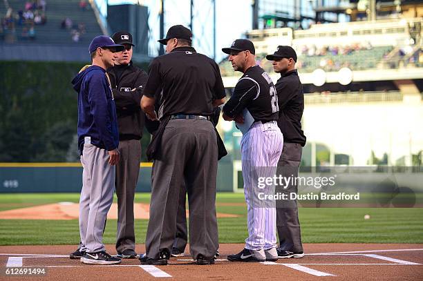 Walt Weiss of the Colorado Rockies and Craig Counsell of the Milwaukee Brewers meet with umpires to go over ground rules before a game at Coors Field...