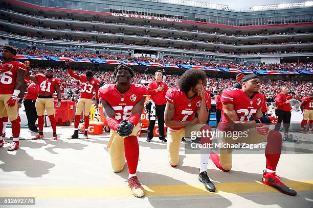 Antoine Bethea and Rashard Robinson of the San Francisco 49ers raise their first during the anthem as Eli Harold while teammates Colin Kaepernick and...