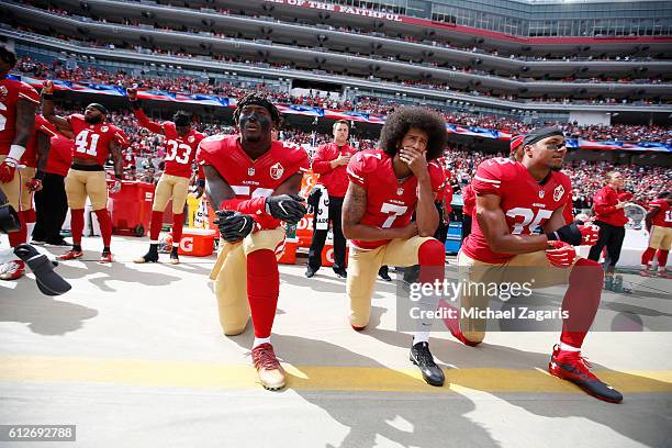 Antoine Bethea and Rashard Robinson of the San Francisco 49ers raise their first during the anthem as Eli Harold while teammates Colin Kaepernick and...