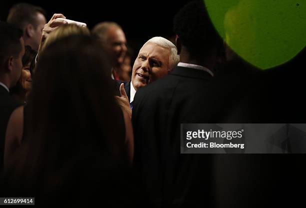 Mike Pence, 2016 Republican vice presidential nominee, center, takes a selfie photograph with an attendee after the vice presidential debate at...