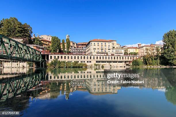 abandoned hotel on one bank of the dora baltea river and ivrea cityscape in piedmont, italy - ivrea stock pictures, royalty-free photos & images