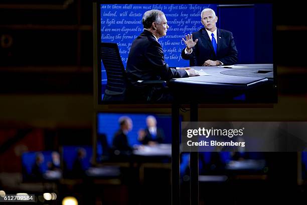 Mike Pence, 2016 Republican vice presidential nominee, right, and Tim Kaine, 2016 Democratic vice presidential nominee, are aeen on television...