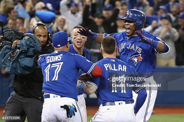 Edwin Encarnacion of the Toronto Blue Jays celebrates with teammates after hitting a three-run walk-off home run in the eleventh inning to defeat the...