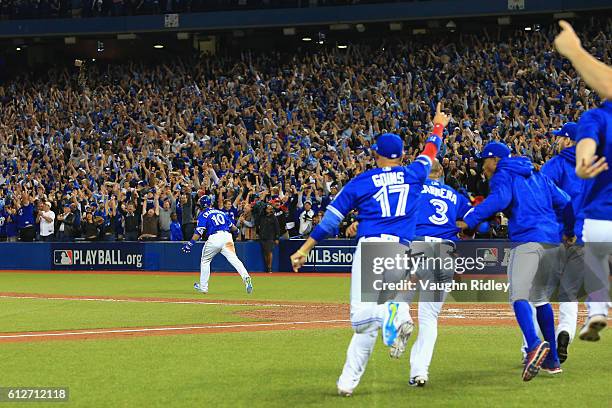 Edwin Encarnacion of the Toronto Blue Jays reacts after hitting a three-run walk-off home run in the eleventh inning to defeat the Baltimore Orioles...