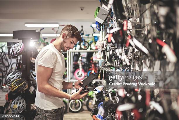 hombre en tienda de bicicletas - artículos deportivos fotografías e imágenes de stock