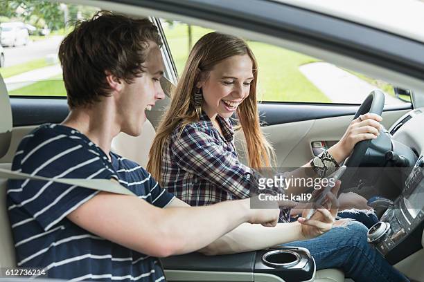 two teenagers in a car, girl driving - distracted driving stock pictures, royalty-free photos & images