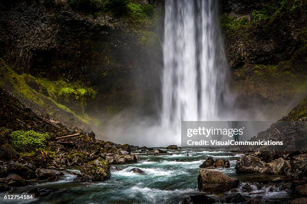 man standing close to huge waterfall. - catarata imagens e fotografias de stock