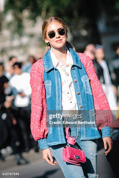 Chiara Ferragni is wearing blue denim jeans, a pink and blue denim jacket, and a pink Chanel bag, outside the Chanel show, during Paris Fashion Week...