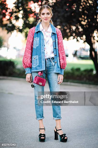 Chiara Ferragni is wearing blue denim jeans, a pink and blue denim jacket, and a pink Chanel bag, outside the Chanel show, during Paris Fashion Week...