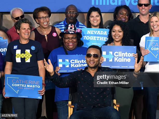 Singer/songwriter John Legend sits onstage to listen to his wife, model and television personality Chrissy Teigen speak at a campaign event with U.S....