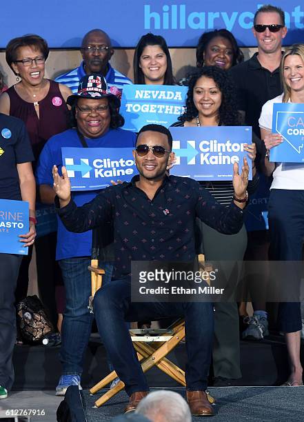 Singer/songwriter John Legend sits onstage to listen to his wife, model and television personality Chrissy Teigen speak at a campaign event with U.S....