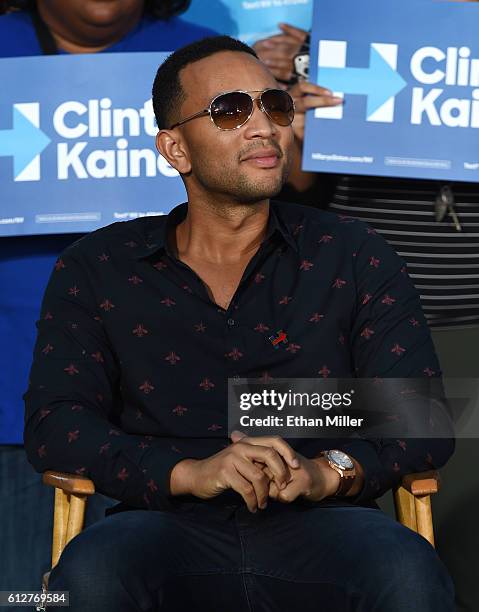 Singer/songwriter John Legend sits onstage to listen to his wife, model and television personality Chrissy Teigen speak at a campaign event with U.S....