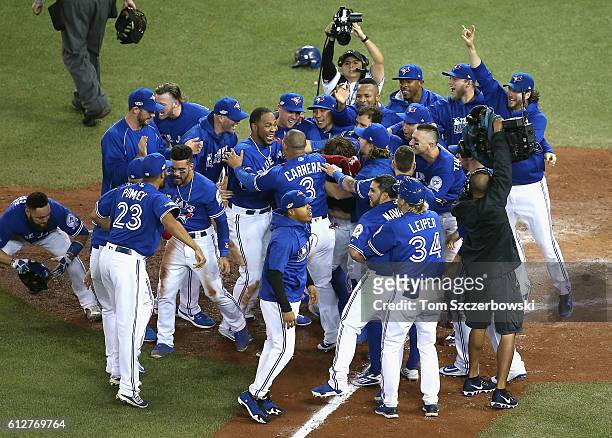 Edwin Encarnacion of the Toronto Blue Jays celebrates with teammates after hitting a three-run walk-off home run in the eleventh inning to defeat the...
