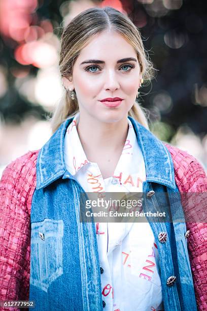Chiara Ferragni is wearing blue denim jeans, a pink and blue denim jacket, and a pink Chanel bag, outside the Chanel show, during Paris Fashion Week...